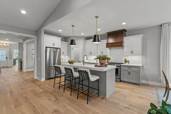 a kitchen with stainless steel appliances kitchen island granite countertop a sink and a refrigerator