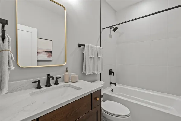 a bathroom with a granite countertop sink toilet and shower