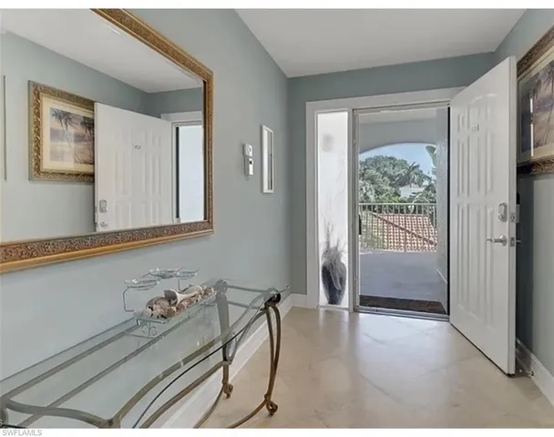 a view of a dining room and livingroom with furniture wooden floor a chandelier
