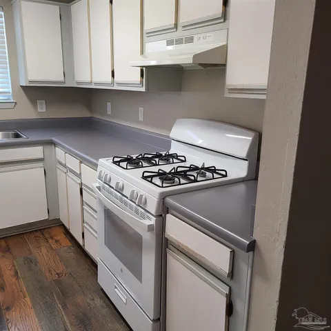 a white stove top oven sitting inside of a kitchen