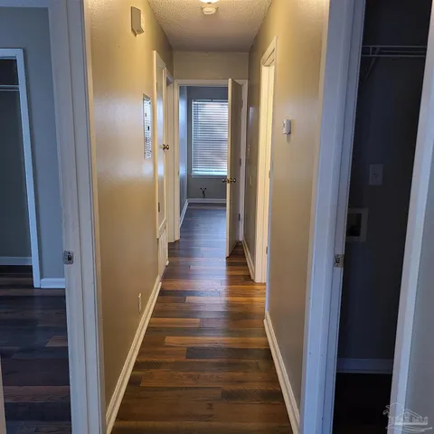 a view of a hallway with wooden floor and staircase