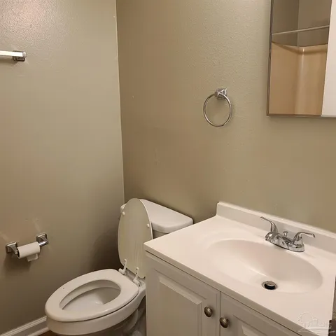 a bathroom with a sink mirror vanity and toilet