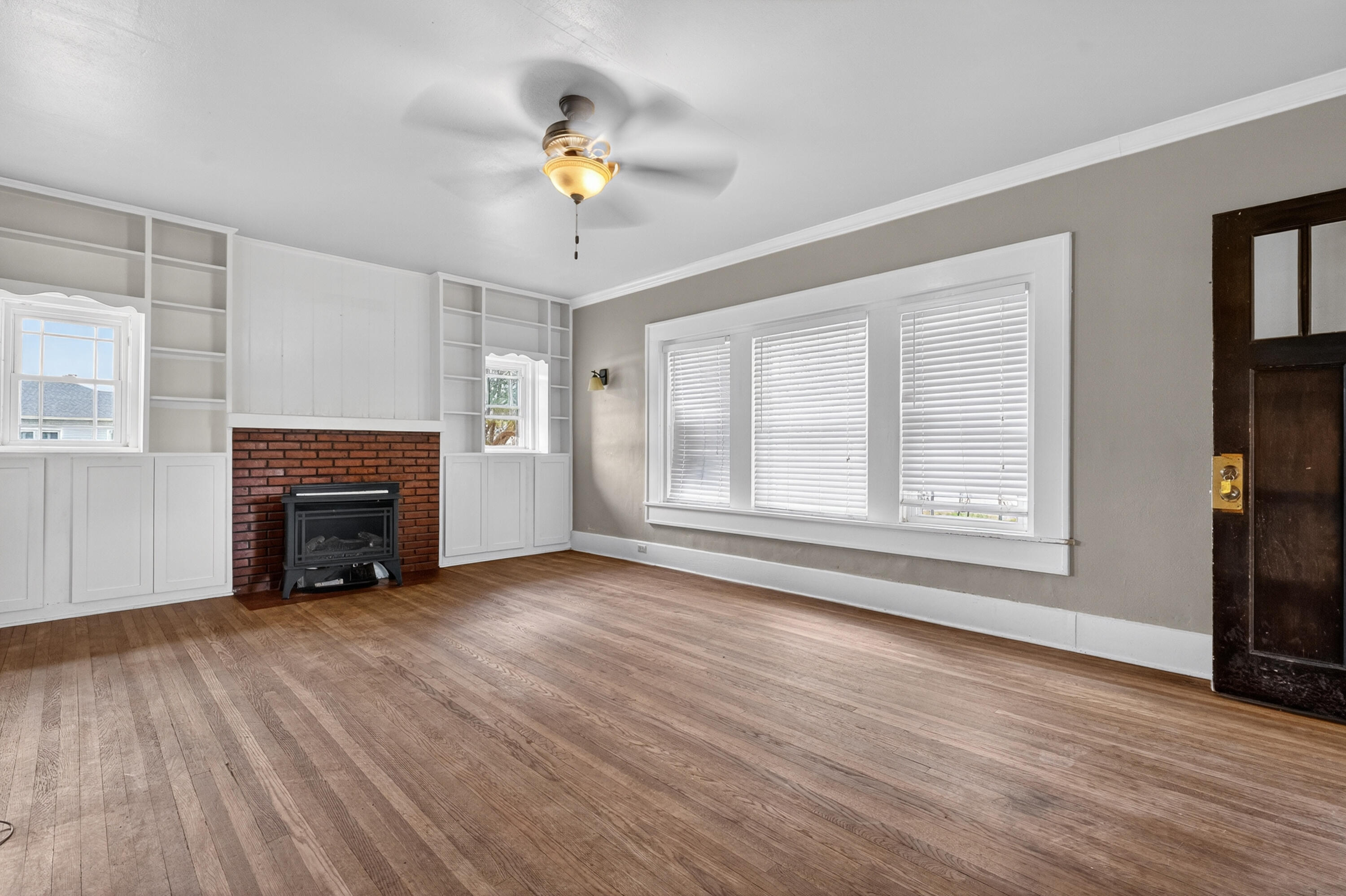 500 West Garza Street Slaton, TX 79364 - Photo 4 of 24 a view of an empty room with wooden floor fireplace and a window