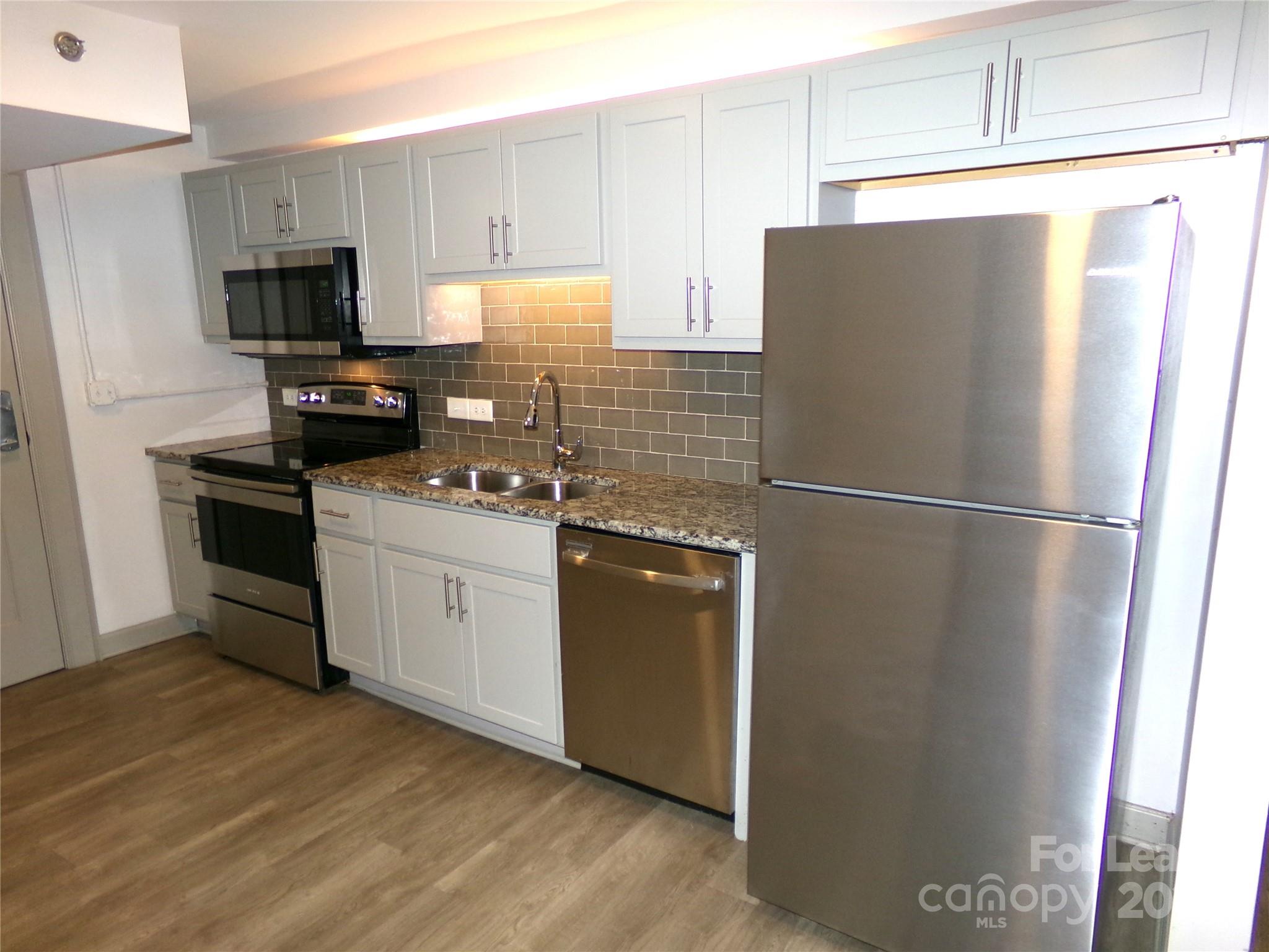 197 North 2nd Street, Unit 5 Albemarle, NC 28001 - Photo 4 of 12 a kitchen with a refrigerator stove and microwave