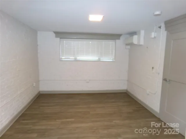 a view of a room with wooden floor and window
