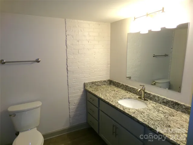 a bathroom with a granite countertop sink toilet and shower