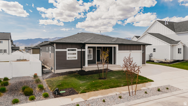 4595 North Fallow Way, Unit 511 Eagle Mountain, UT 84005 - Photo 1 of 32 View of front of property with board and batten siding, roof with shingles, driveway, a garage, and a mountain view