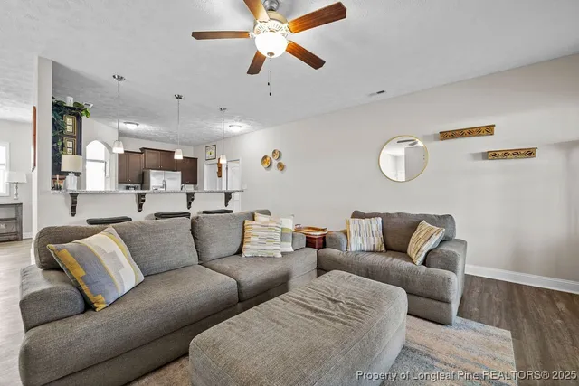 a living room with furniture kitchen view and a chandelier
