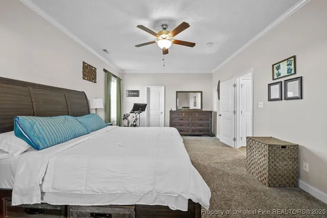 a bedroom with a bed a couch and a ceiling fan