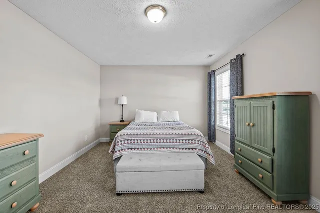 a bedroom with a white bed and a dresser