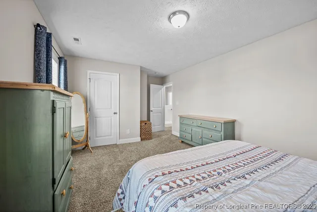a bedroom with a large bed and wooden floor