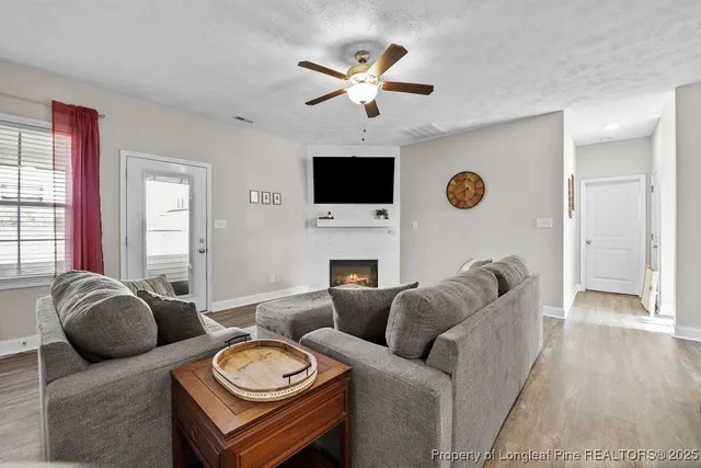 a living room with furniture a fireplace and a flat screen tv