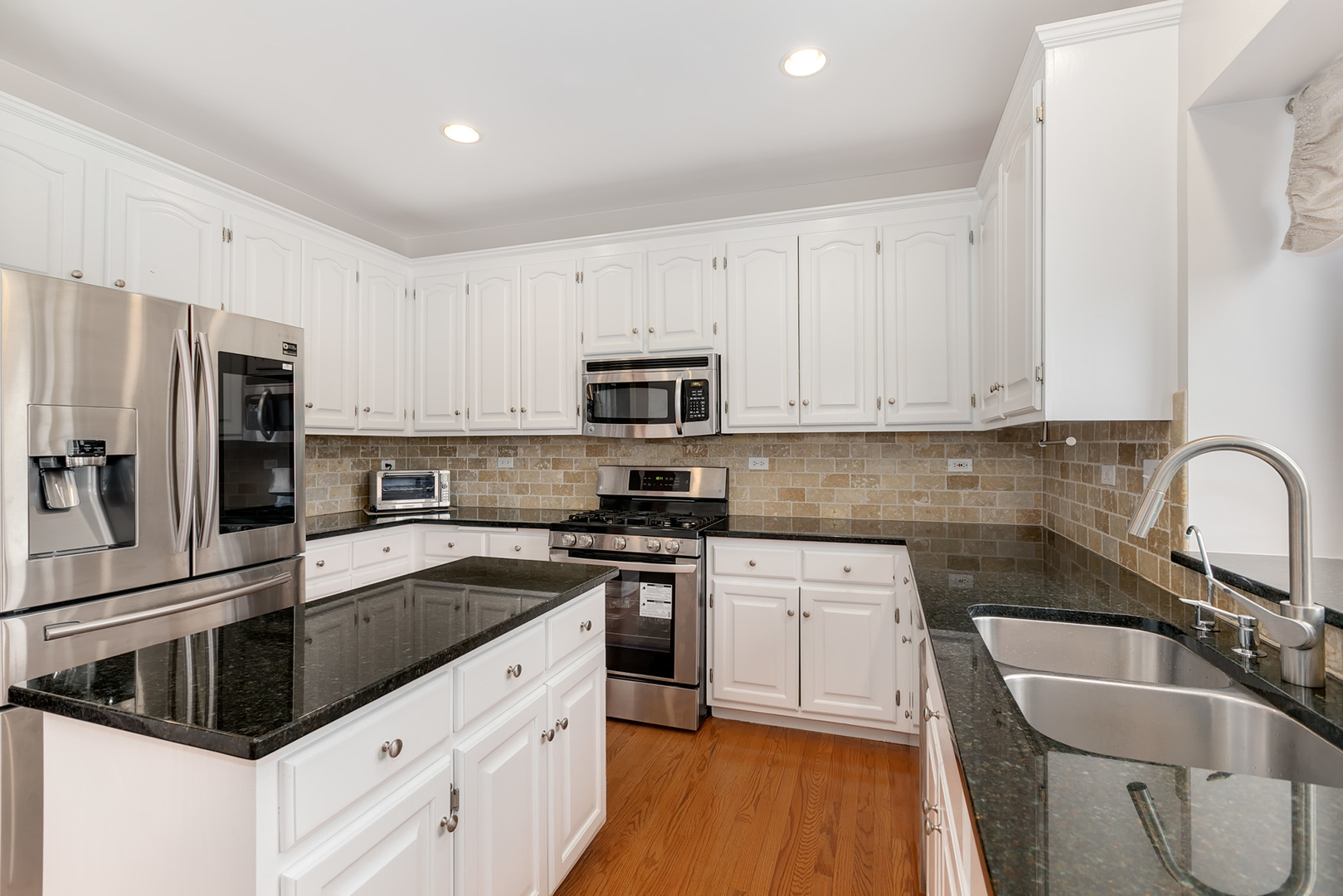 464 Lewis Road Geneva, IL 60134 - Photo 10 of 33 a kitchen with granite countertop white cabinets and stainless steel appliances