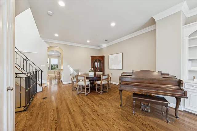 a living room with furniture a piano and wooden floor