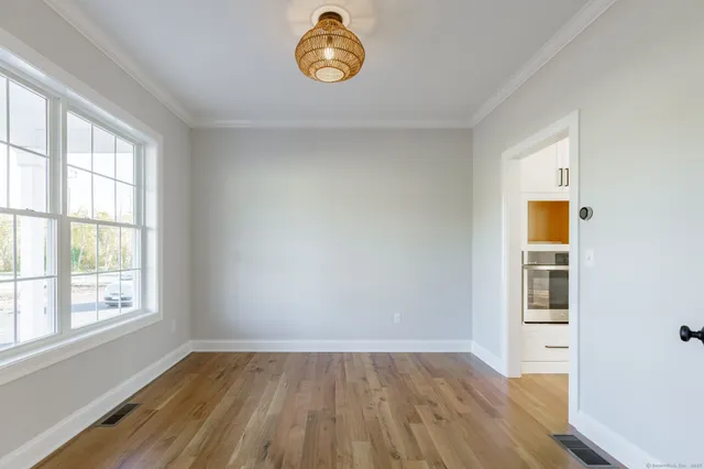 an empty room with a window and wooden floor