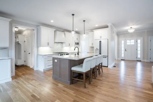 a kitchen with kitchen island white cabinets and refrigerator