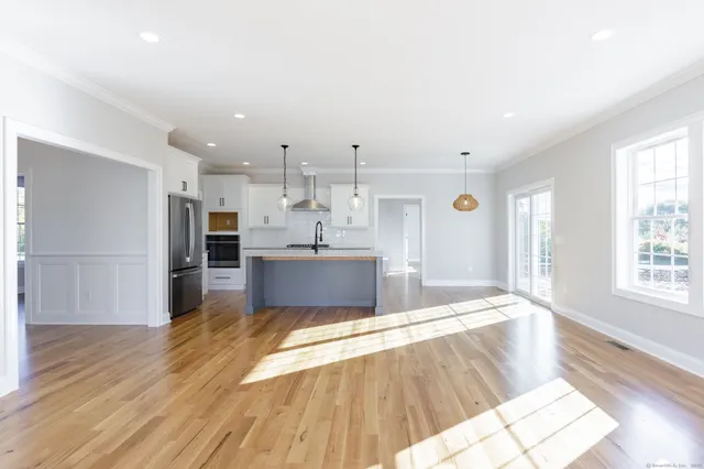 a large kitchen with stainless steel appliances kitchen island a large counter top and a wooden floors