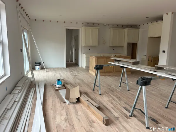 a kitchen with stainless steel appliances kitchen island granite countertop a refrigerator a sink a oven and a wooden floors