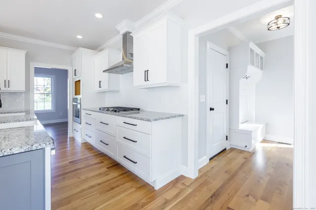 a kitchen with stainless steel appliances granite countertop a stove and a wooden floors