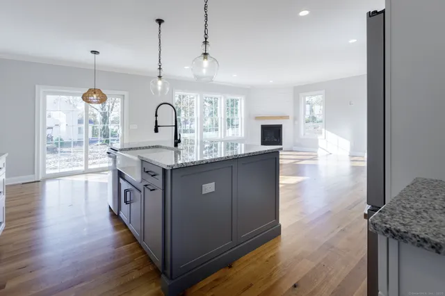 a kitchen with granite countertop a sink cabinets and wooden floor