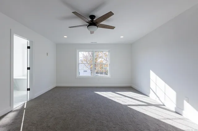 en empty room with windows and ceiling fan