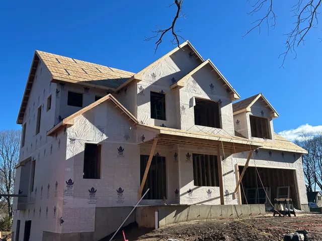 a front view of a house with a tree