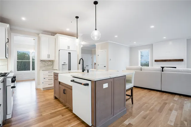 a kitchen that has a lot of cabinets in it and wooden floors