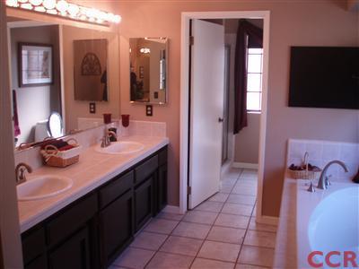 8550 Corriente Road Atascadero, CA 93422 - Photo 10 of 15 a en suite bathroom with a double vanity sink a mirror and a bathtub