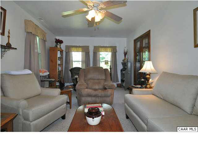 The bright, comfortable family room is fully carpeted and equipped with ceiling fan.