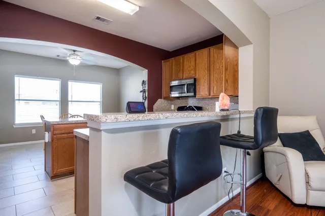 a kitchen with a table chairs appliances and cabinets