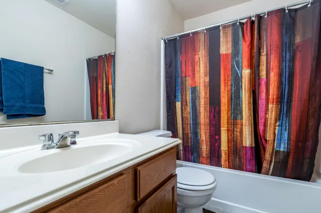 a bathroom with a sink a toilet and a mirror