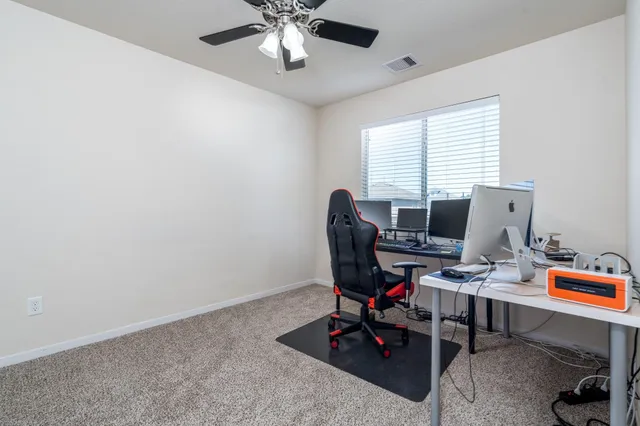 a view of a workspace with furniture and a window