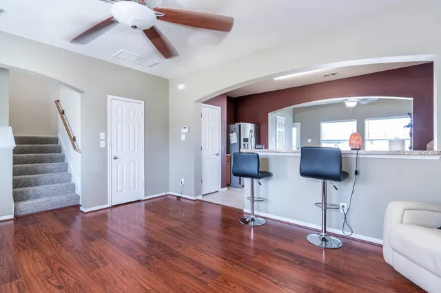 a view of a livingroom with wooden floor and furniture