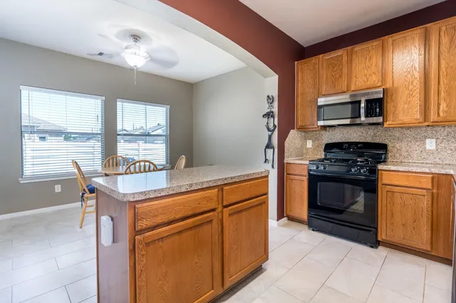 a kitchen with stainless steel appliances granite countertop a stove a sink and a microwave