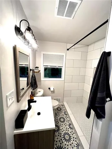 a bathroom with a sink a toilet and mirror