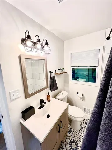 a bathroom with a sink toilet and mirror