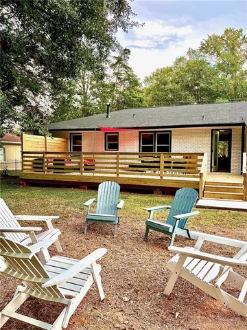 a view of a patio with table and chairs with wooden floor and fence
