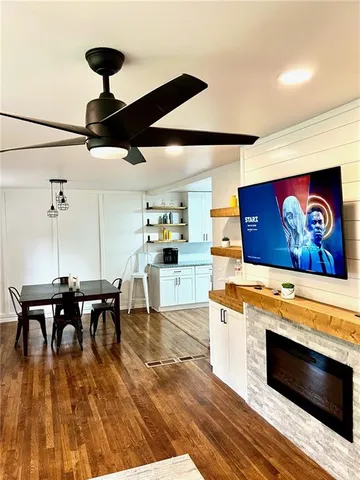 a kitchen with stainless steel appliances kitchen island granite countertop a table chairs and a wooden floor
