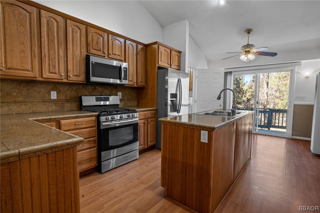 307 Riverside Avenue Sugarloaf, CA 92386 - Photo 9 of 31 a kitchen with stainless steel appliances granite countertop a stove a sink dishwasher a microwave oven and a refrigerator with wooden cabinets
