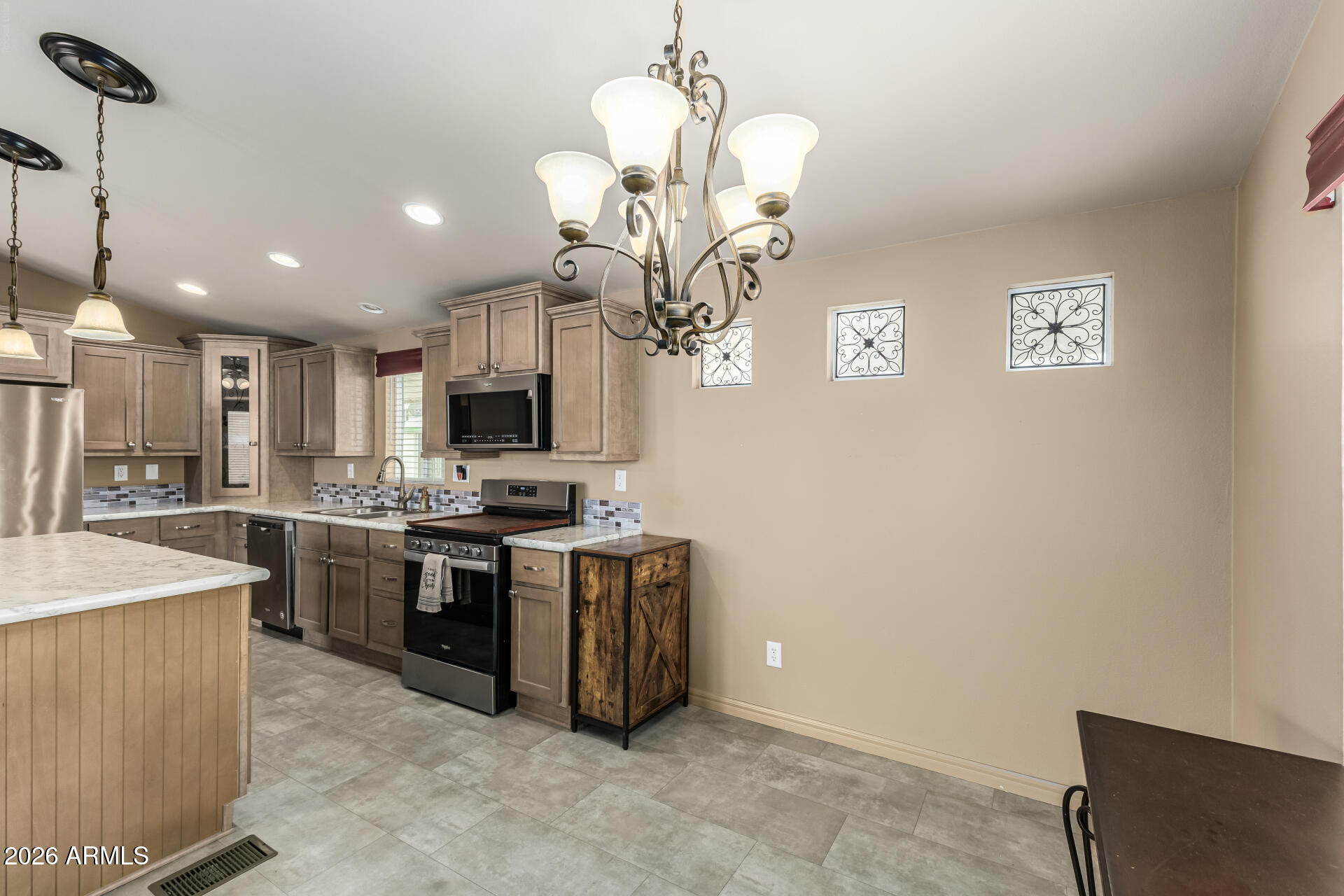 9302 East Broadway Road, Unit 117 Mesa, AZ 85208 - Photo 9 of 24 a large kitchen with stainless steel appliances granite countertop a sink dishwasher a stove top oven a refrigerator and a dining table with wooden floor