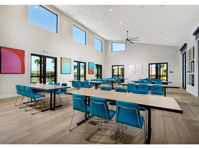 a room with stainless steel appliances lots of wooden furniture table and chairs