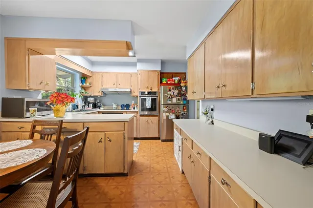 a kitchen with a sink a counter top space stainless steel appliances and cabinets