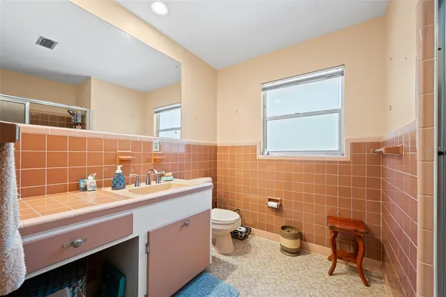 a bathroom with a sink mirror and toilet