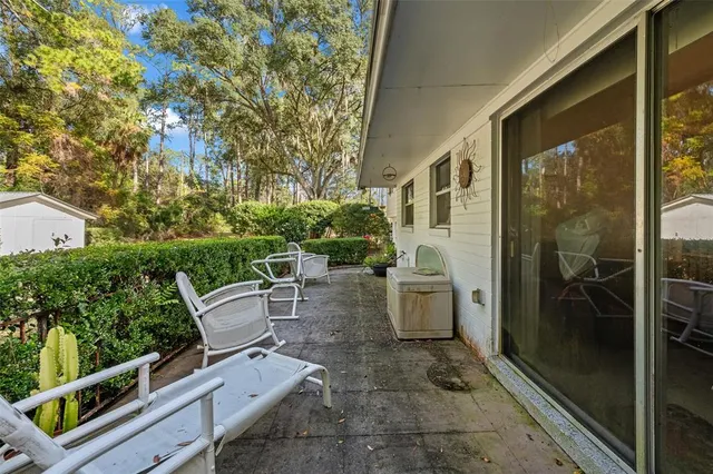 a view of a porch with chairs and wooden fence