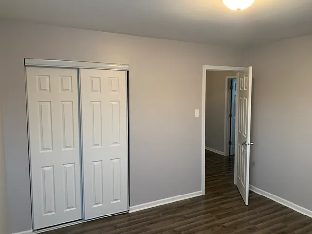 an empty room with wooden floor and closet area