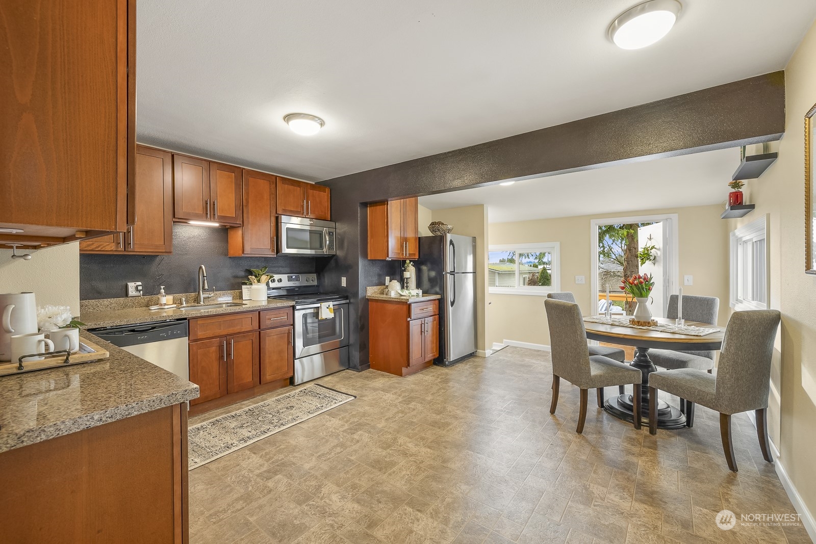 807 Edmonds Avenue Northeast Renton, WA 98056 - Photo 6 of 38 a kitchen with stainless steel appliances granite countertop a stove top oven a sink dishwasher a dining table and chairs with wooden floor