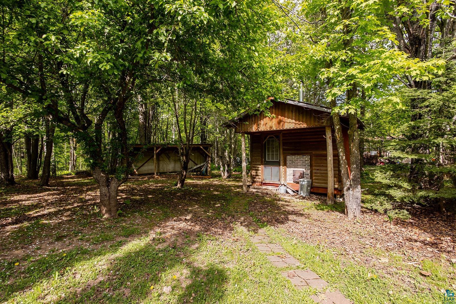 7045 Morris Thomas Road Cloquet, MN 55720 - Photo 24 of 28 Wood-sided sauna featuring a covered porch entrance with a distinctive arched window