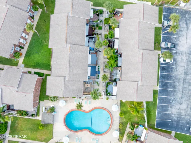 an aerial view of a city with lots of residential buildings ocean and mountain view in back