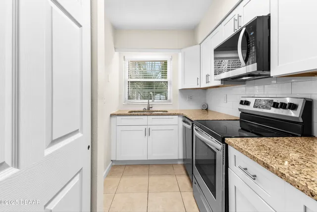 a kitchen with stainless steel appliances granite countertop a sink and a stove