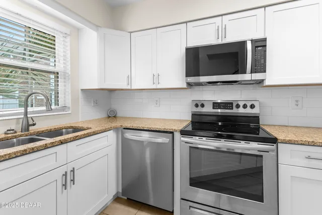 a kitchen with cabinets stainless steel appliances a sink and a counter space